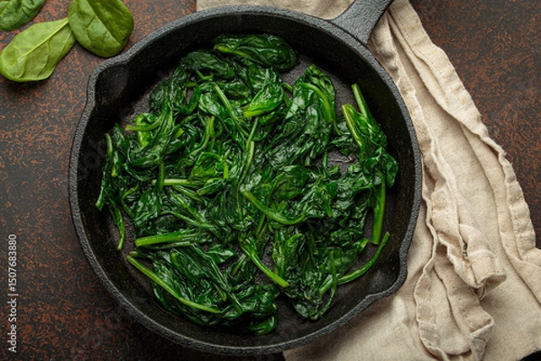 Obraz Freshly steamed spinach leaves are served in a cast iron pan, a nutritious and flavorful side dish or ingredient for healthy meals