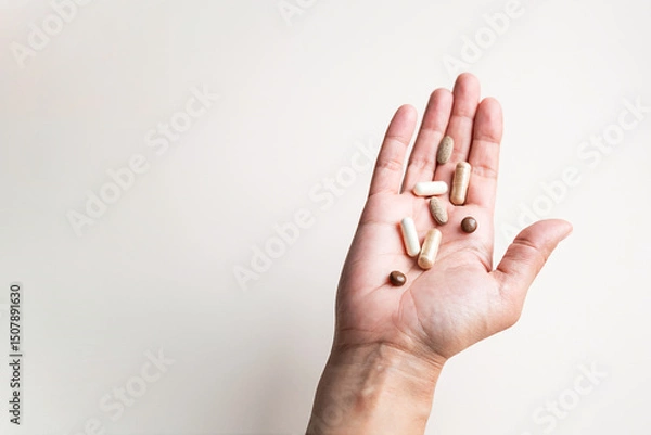 Fototapeta Open Hand Holding Variety of Different Natural Pills and Capsules, Promoting Healthcare and Wellness.
