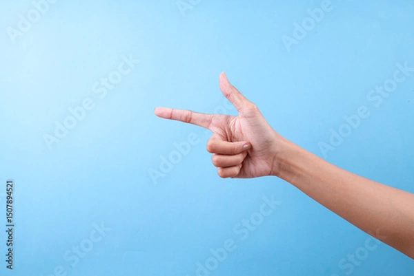 Obraz Hand Making Pointing Gesture To The Left Against A Blue Background