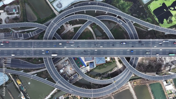 Obraz Multi-level overpass China. Lot cars drive on transportation interchange. Road traffic. Chinese economy. Aerial top drone above view of fast urban highway. Modern city freeway. Busy auto express way.
