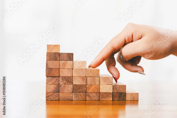 Fototapeta Business risk control concept, Businesswoman protect wooden block fall to planning and strategy in risk to business alternative and prevent. investment insurance business.