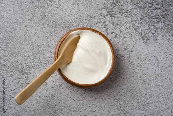 Fototapeta Top view of yogurt in bowl on grey stone table. Healthy eating concept