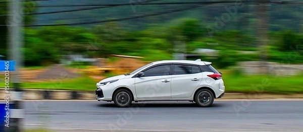 Fototapeta Motion blur in the background emphasizes the car's high speed.