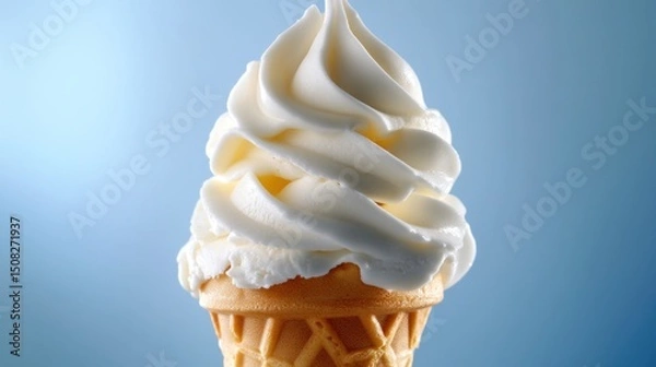 Fototapeta Soft serve vanilla ice cream in a waffle cone against a blue background.