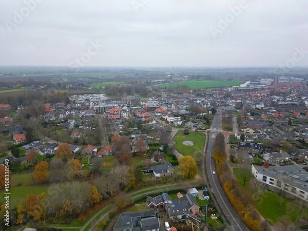 Fototapeta Geldermalsen, Netherlands - 03.15.2023 : Aerial view of a Dutch town in cloudy spring weather. The infrastructure of the Netherlands at high standards, a combination of old and new buildings 