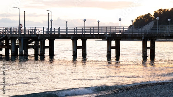 Obraz Seaside Pier at Sunset with Soft Reflections on Water — Tranquil Coastal Landscape