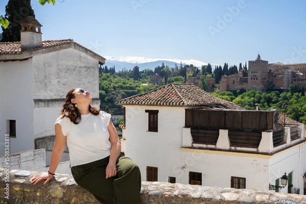 Fototapeta Tourist enjoying the view of alhambra palace and sierra nevada mountains in granada, spain