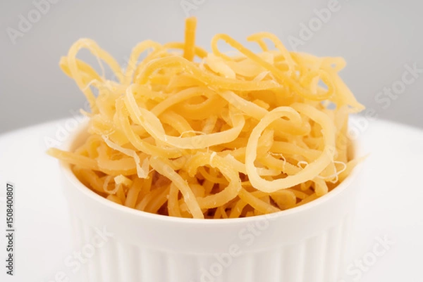 Fototapeta Beer snack made of dried squid. Dried squid isolated on white background. Dried squid shavings. Small fish, shrimp and squid that have been marinated with salt and dried