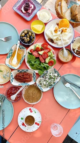 Fototapeta Traditional Turkish breakfast served on a colorful table with various cheeses, vegetables, olives, jams, honey, bread and coffee, vertical, concept of Turkish kitchen and travel