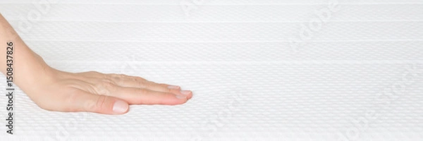 Fototapeta Young adult woman hand touching clean white orthopedic mattress. Checking hardness and softness. Closeup. Wide banner. Empty place for text. Front view.