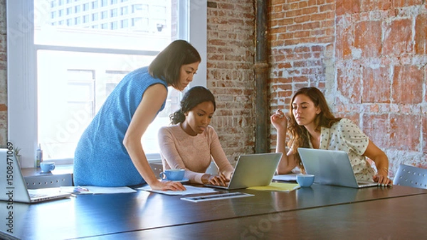 Obraz Multi-Cultural Group Of Businesswomen Working Together In Boardroom
