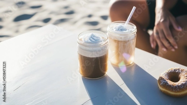 Fototapeta Refreshing cold brew coffee drinks on a beachside picnic table with vegan donuts during a summer afternoon