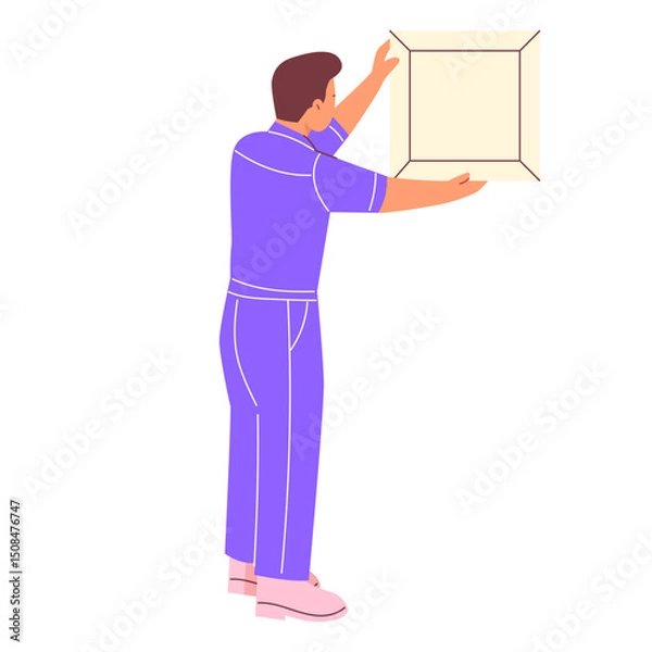 Obraz A man in a work uniform hangs a painting on the wall