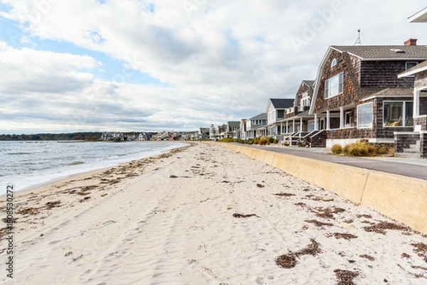 Fototapeta Traditional American wooden houses along a deserted sandy beach on a cloudy autumn day