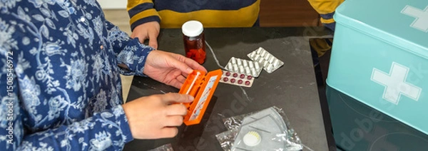 Fototapeta Unrecognizable mother showing how to use medical injection with pre filled syringe to son while organizing first aid emergency kit, providing healthcare guidance and education. 72 hour survival kit.