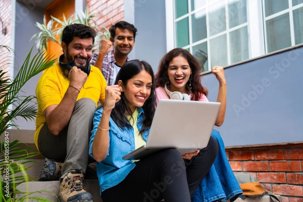 Obraz Indian classmates using laptop and books while studying together in friendly outdoor campus setting