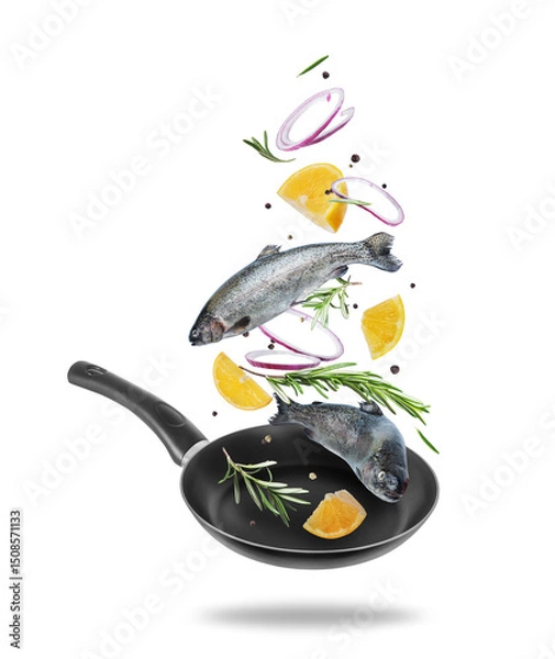 Fototapeta Sea trout with rosemary branches and lemon slices falling into frying pan on white background