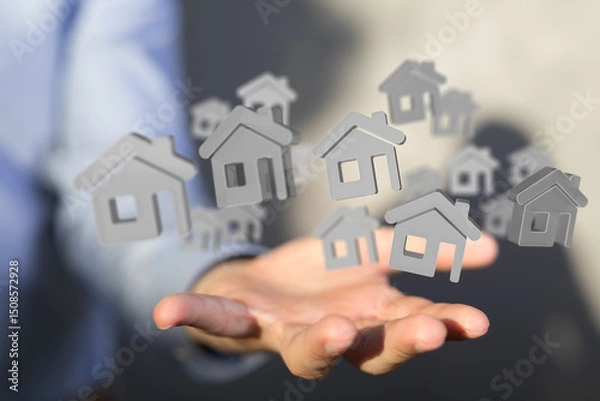 Fototapeta Image of a hand holding multiple digital house icons, ideal for real estate, property, and home concepts.