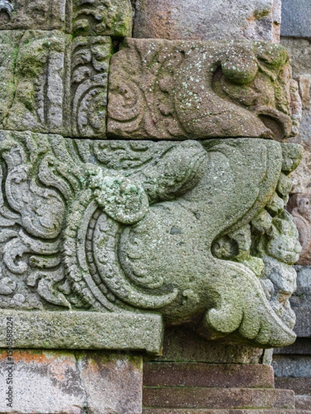 Obraz Closeup vertical view of makara head stone carving on ancient hindu Gedong Songo I temple wall Bandungan, Semarang, Java, Indonesia