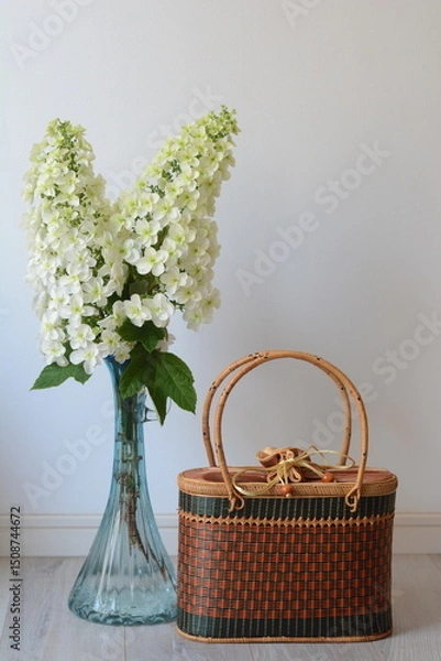 Obraz 花瓶に飾った柏葉アジサイと籠バックのテーブルフォト