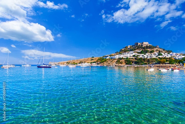 Fototapeta Lindos, Rhodes, Greece: Scenic view of Lindos Acropolis and beach on Rhodes island, Aegean Sea