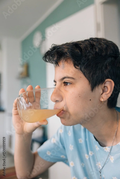 Obraz Teenager girl drinking juice in the morning, following daily routines