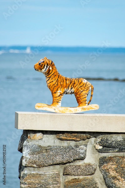 Obraz Stuffed Tiger on a ledge with the water in the background 