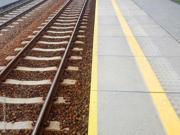 Fototapeta Empty railway station with rail tracks. Train platform
