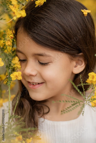 Obraz Closeup spring or summer portrait of little smiling girl with blooming yellow flowers, childhood memories and happy kids portrait