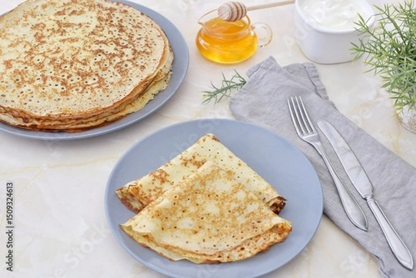 Obraz Thin pancakes on a plate, next to honey and sour cream.