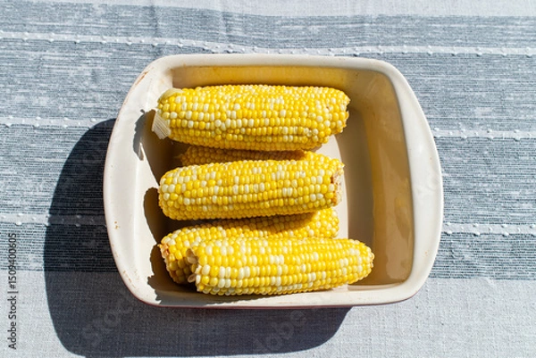 Obraz corn on the cob in a bowl on a grey table 