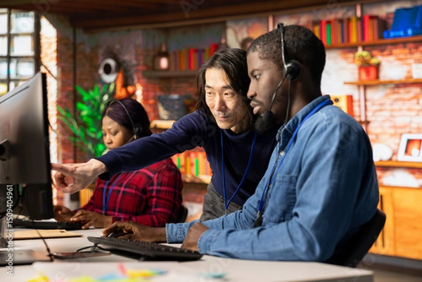 Obraz Asian call center senior manager providing guidance to multiethnic team, addressing questions. Customer support workplace onboarding specialist conducts orientation sessions for multiracial coworkers