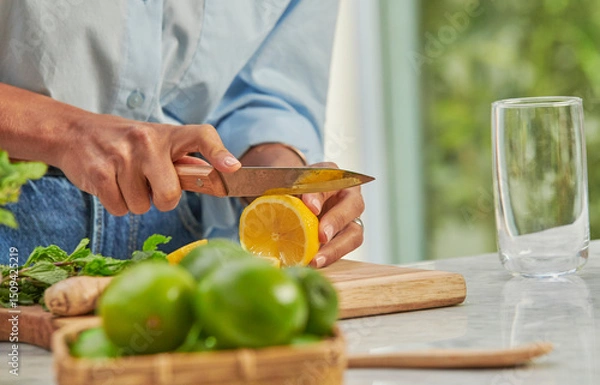 Obraz Manos de mujer con camisa azul cortando limones 