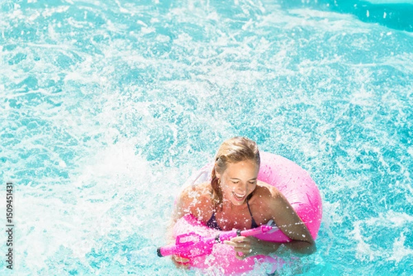 Obraz Pink inflatable ring floating in turquoise pool with water splashing and foaming in sunlight