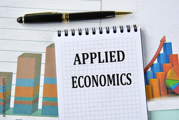 Fototapeta APPLIED ECONOMICS- words in notebook on the background of a chart and a pen