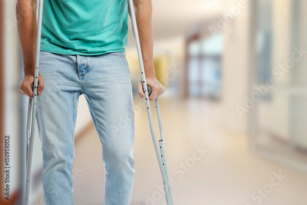 Obraz Man with axillary crutches in hospital, closeup. Space for text