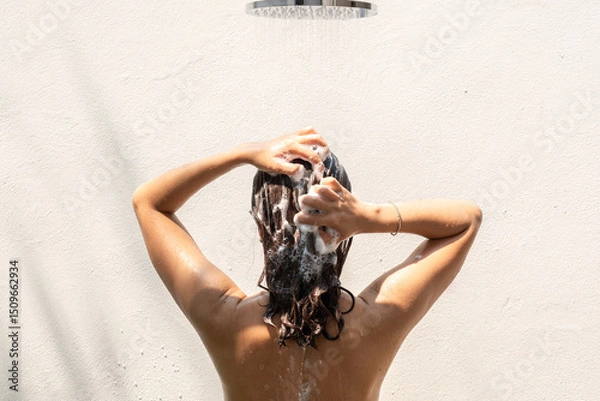 Fototapeta Beautiful woman's hand She was washing her hair and nourishing her scalp. Shampoo and conditioner	