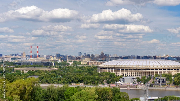 Fototapeta Breathtaking view of Moscow skyline from Vorobyovy Gory, with Moscow River, green trees, and clouds in the blue sky
