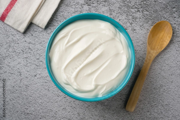 Fototapeta Top view of yogurt in bowl on grey stone table. Healthy eating concept