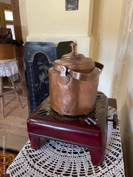 Obraz A copper pot sits on a red stand