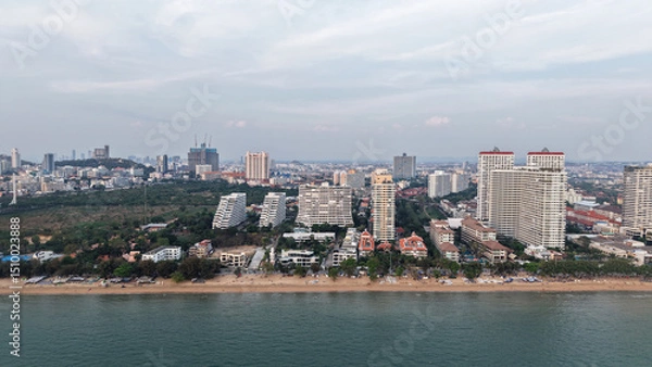 Fototapeta Modern buildings rising along the pattaya coastline create a stunning cityscape against the ocean backdrop as twilight approaches, blending urban development with natural beauty