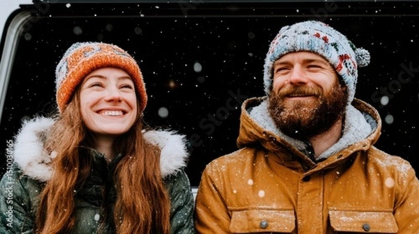 Fototapeta Winter Bliss: A Warm Embrace of Love Amidst Falling Snow: This photograph showcases a loving couple enjoying a winter scene. The man and woman share a moment of happiness.
