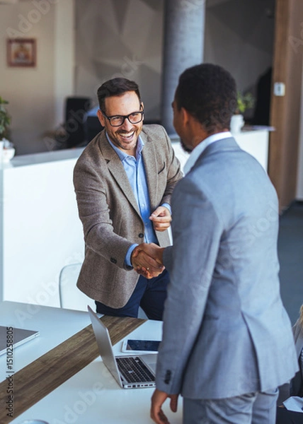 Fototapeta Businessmen Shaking Hands During a Meeting Inside a Modern Office Setting