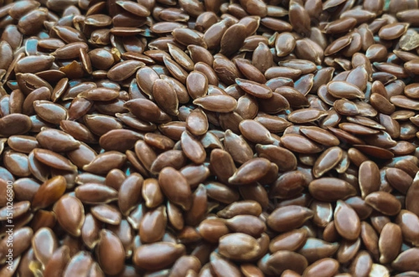 Fototapeta Macro close-up of raw brown flax seeds scattered in a natural pattern. These nutritious seeds are known for their health benefits, omega-3 content, and are used in healthy diets, baking, and cooking.