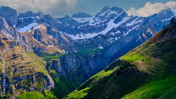 Fototapeta Breathtaking mountain landscape with snow-capped peaks and lush green valleys in a serene natural setting