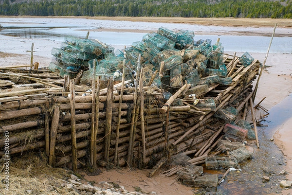 Fototapeta A pier wharf filled with lobster traps that has collapsed. The wharf is broken in the middle, and traps have fallen into the bay at low tide.