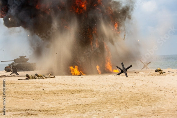 Obraz World War II historical reconstruction. Battlefield. Explosions, a tank, and American soldiers on the beach. Smok and dust.