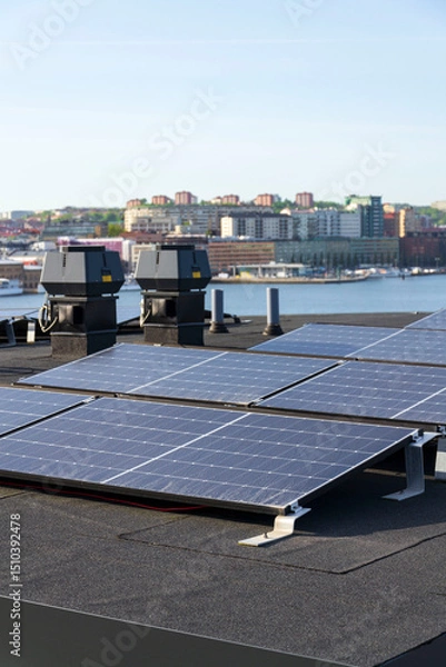 Obraz Solar panels on roof of apartment housing building with Gothenburg city center in background, Sweden, renewable green sustainable energy concept
