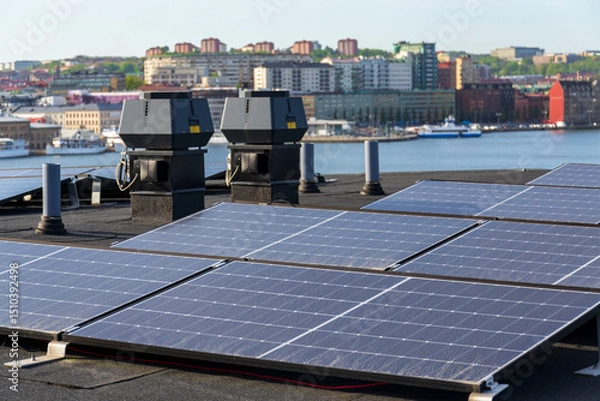 Obraz Solar panels on roof of apartment housing building with Gothenburg city center in background, Sweden, renewable green sustainable energy concept