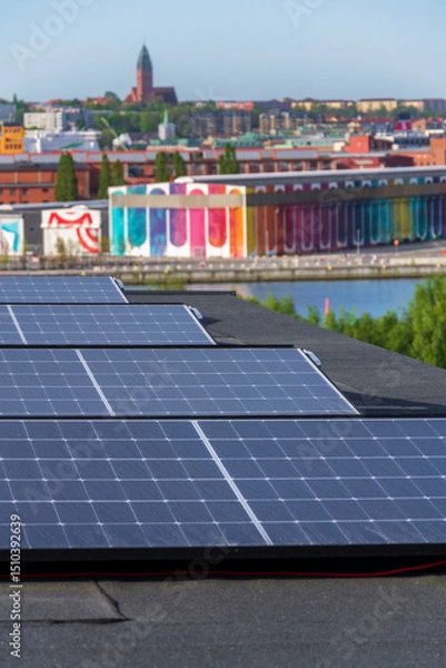 Obraz Solar panels on roof of apartment housing building with Gothenburg city center in background, Sweden, renewable green sustainable energy concept